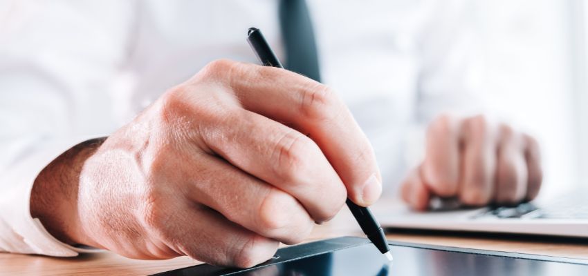 The man is using eSignature to sign contracts.