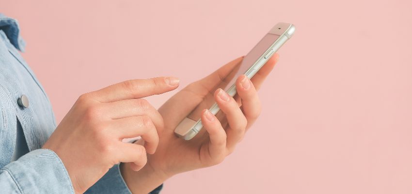 A close-up view of a person holding a mobile phone using a mobile-friendly signing application.