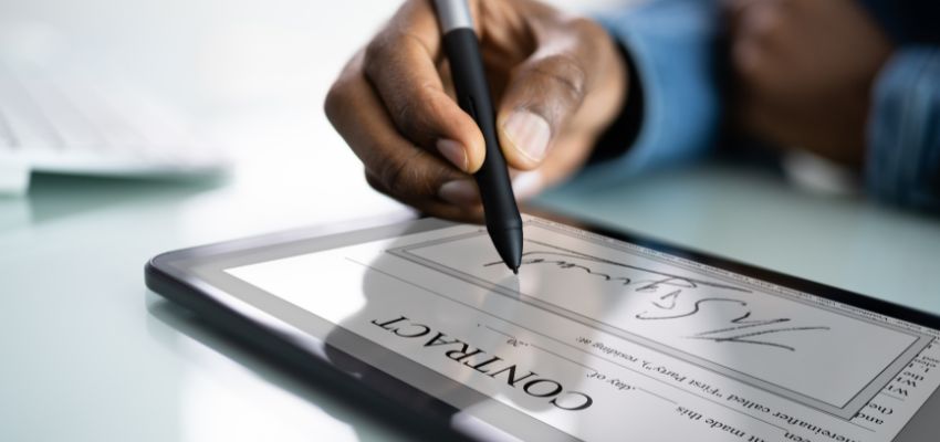 A person signing a business document with a pp signature.