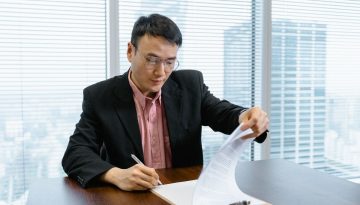 The businessman signs a business agreement.