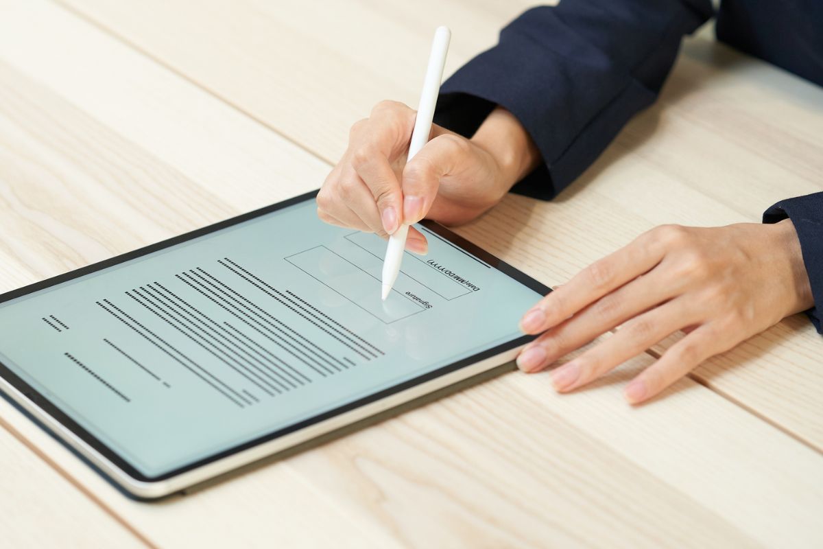 The businessman signs a digital contract.