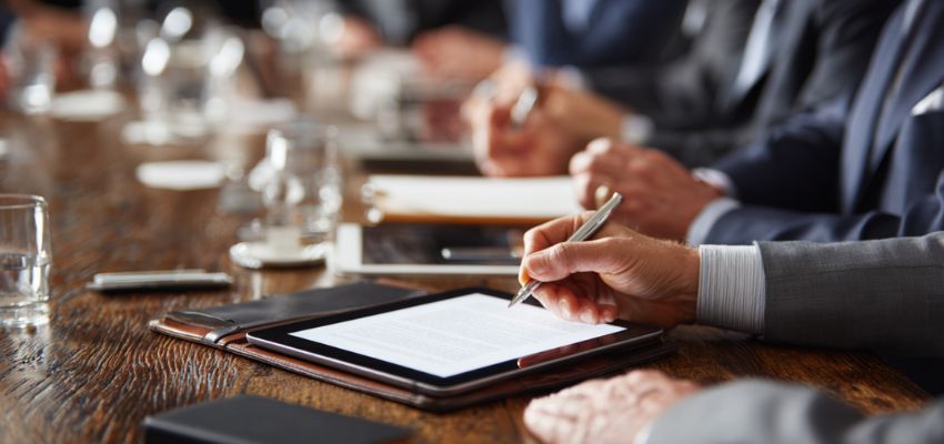 Man signing a digital document on a tablet — demonstrating signatories meaning in electronic or digital contracts.