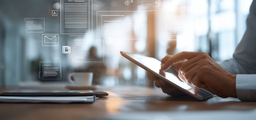 Business professional in a modern office interacting with a tablet displaying digital documents, emails, and icons, powered by advanced contract collaboration software for seamless team workflows.