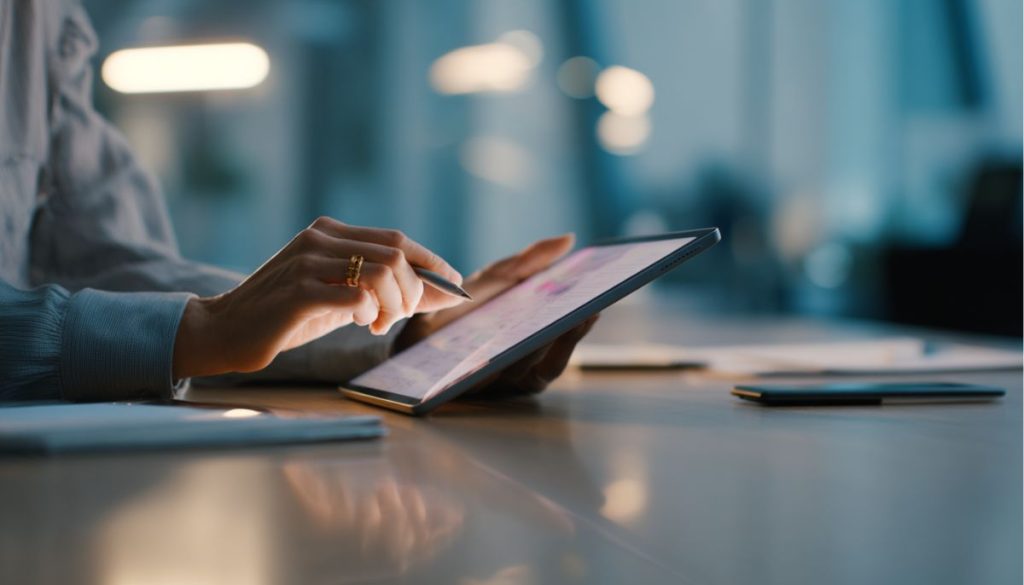 Close-up of hands using stylus to review contract strategies on a tablet device