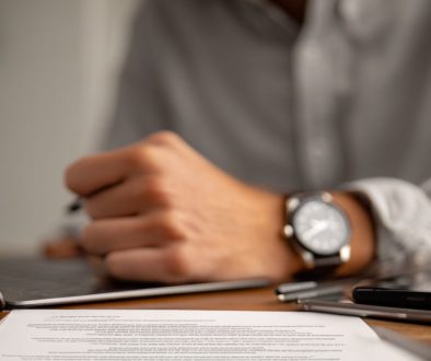 Close-up of professional reviewing paperwork showing types of contract